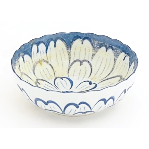 49A - A Japanese blue and white bowl with floral decoration and petal brushwork detail. Character marks un... 