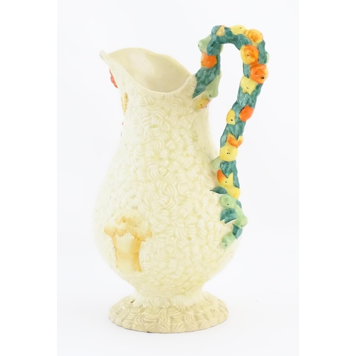 79 - A Clarice Cliff harvest jug decorated with moulded fruit handle, the baluster body decorated with re... 