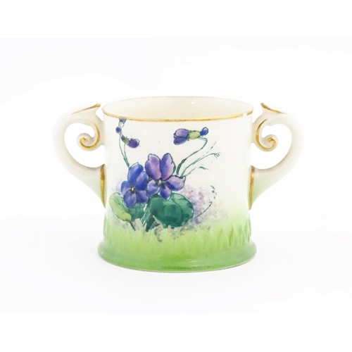 105 - A miniature Royal Worcester loving cup with scrolled handles, decorated with flowers and foliage. Ma... 