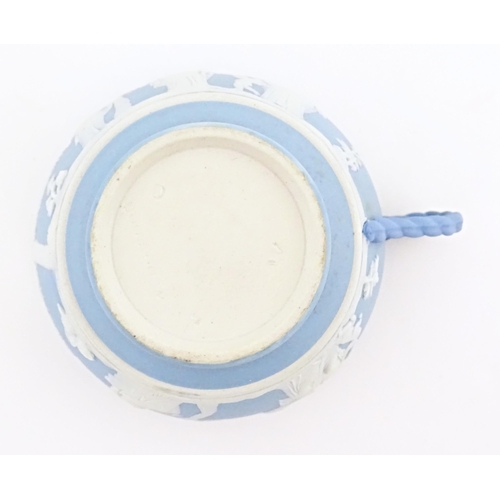 121 - A Wedgwood Jasperware tea cup and saucer decorated with classical figures in relief. Cup approx. 2