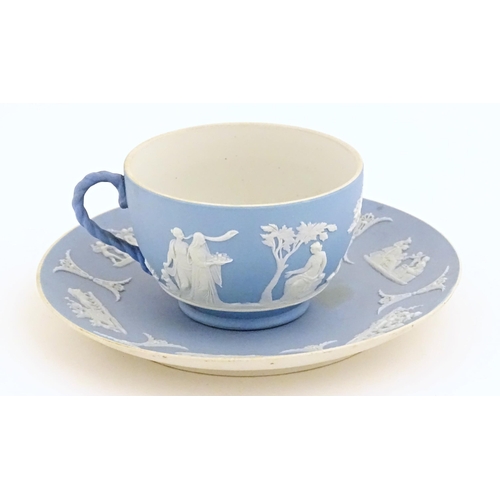 121 - A Wedgwood Jasperware tea cup and saucer decorated with classical figures in relief. Cup approx. 2