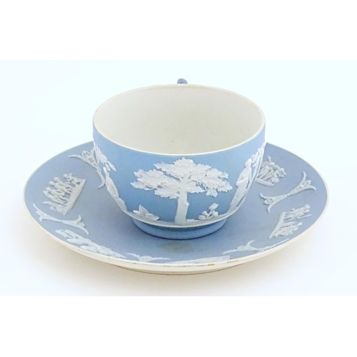 121 - A Wedgwood Jasperware tea cup and saucer decorated with classical figures in relief. Cup approx. 2