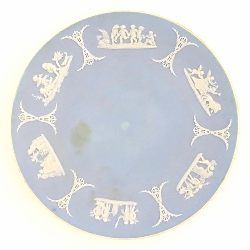 121 - A Wedgwood Jasperware tea cup and saucer decorated with classical figures in relief. Cup approx. 2