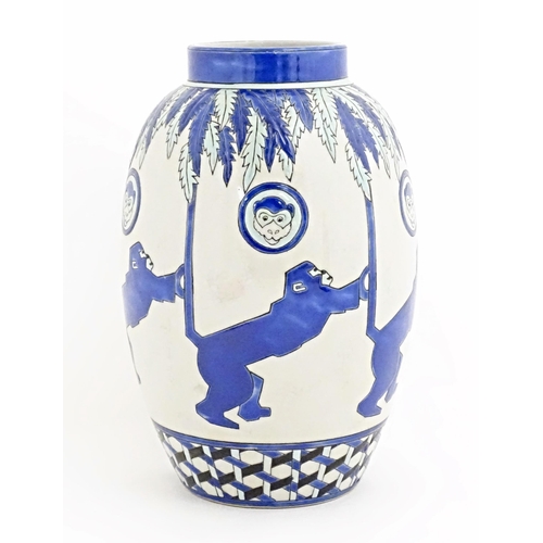 127 - An Art Deco style blue and white vase decorated with banded monkey and palm tree detail. Marked Kera... 