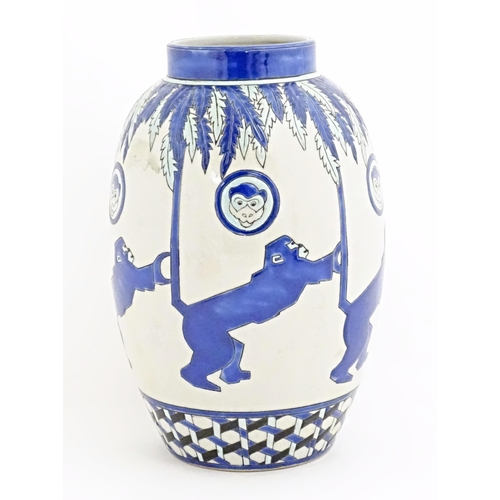 127 - An Art Deco style blue and white vase decorated with banded monkey and palm tree detail. Marked Kera... 