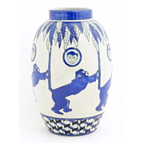 127 - An Art Deco style blue and white vase decorated with banded monkey and palm tree detail. Marked Kera... 