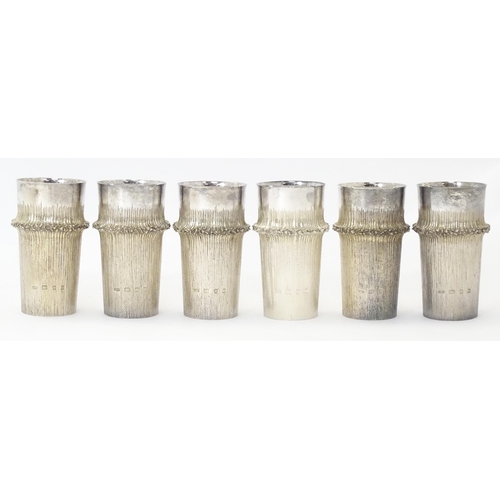 268 - Christopher Nigel Lawrence : An Elizabeth II Modernist set of six silver beakers / cups with texture... 