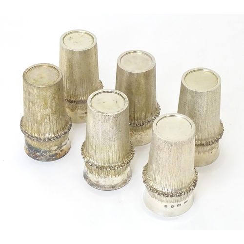 270 - Christopher Nigel Lawrence : An Elizabeth II Modernist set of six silver beakers / cups with texture... 