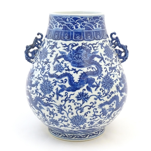 30A - A Chinese blue and white Hu vase with scrolled twin handles, the body decorated with dragons and peo... 