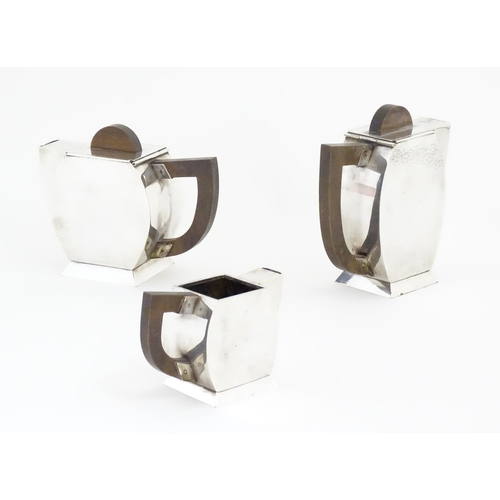 961 - An Art Deco three piece silver plate tea set with hammered decoration and wooden handles, comprising... 