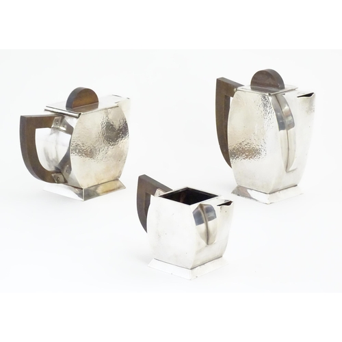 961 - An Art Deco three piece silver plate tea set with hammered decoration and wooden handles, comprising... 