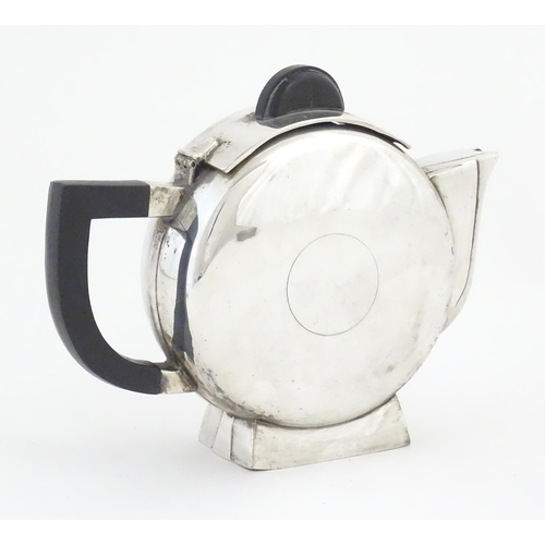 962 - An Art Deco silver plate teapot with ebonised handle and finial, the body with circular detail, in t... 