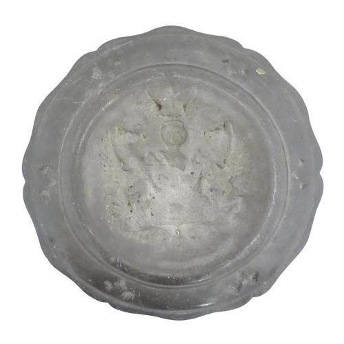 975 - A pewter charger with shaped rim and central heraldic crest / coat of arms. Impressed crowned rose t... 