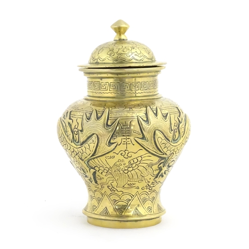 992 - A Chinese cast brass vase and cover of baluster form with relief decoration depicting dragons and a ... 