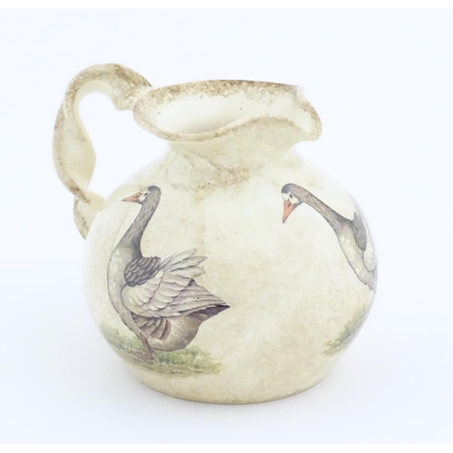 75A - A Yorkshire Moorlands pottery jug with twist handle decorated with geese. Marked under. Approx. 4 1/... 