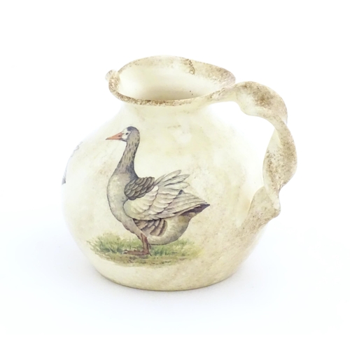 75A - A Yorkshire Moorlands pottery jug with twist handle decorated with geese. Marked under. Approx. 4 1/... 