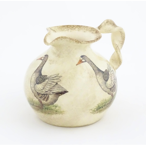 75A - A Yorkshire Moorlands pottery jug with twist handle decorated with geese. Marked under. Approx. 4 1/... 