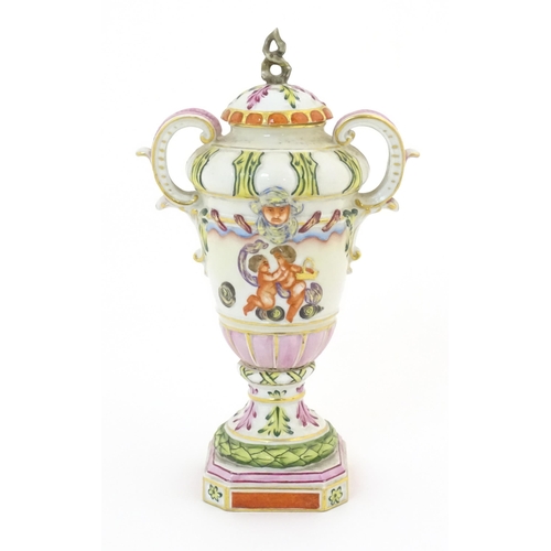 64A - A Capodimonte twin handled vase and cover with hand painted cherub / putti, mask and foliate decorat... 