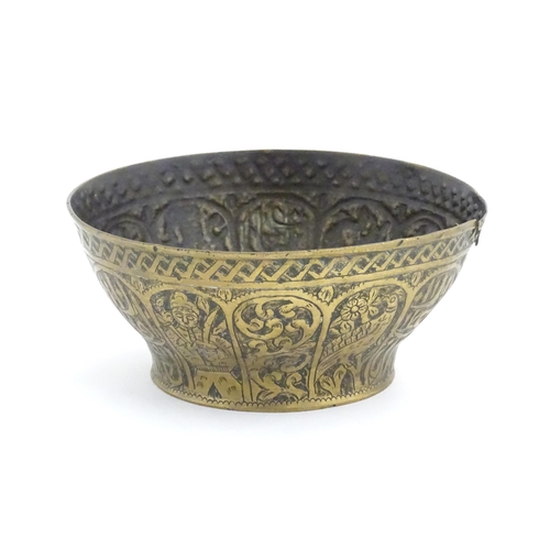 1000 - An Islamic brass bowl with embossed and engraved decoration depicting figures with weapons / arms, b... 