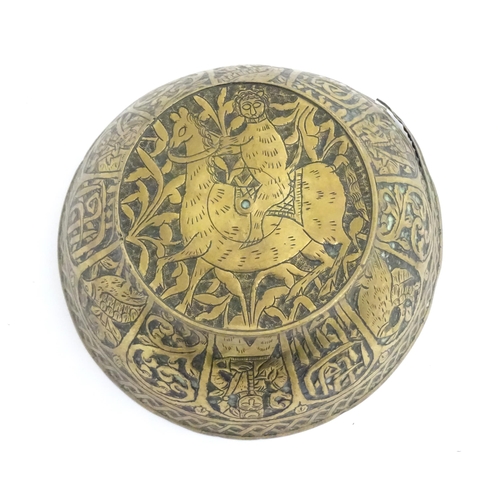 1000 - An Islamic brass bowl with embossed and engraved decoration depicting figures with weapons / arms, b... 