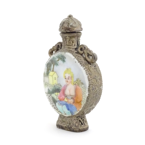 1014 - An Oriental snuff bottle with hand painted decoration depicting a woman in a garden scene. Together ... 