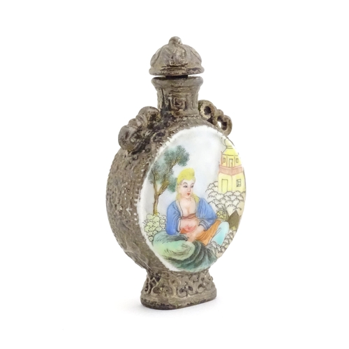 1014 - An Oriental snuff bottle with hand painted decoration depicting a woman in a garden scene. Together ... 