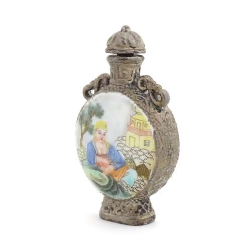 1014 - An Oriental snuff bottle with hand painted decoration depicting a woman in a garden scene. Together ... 