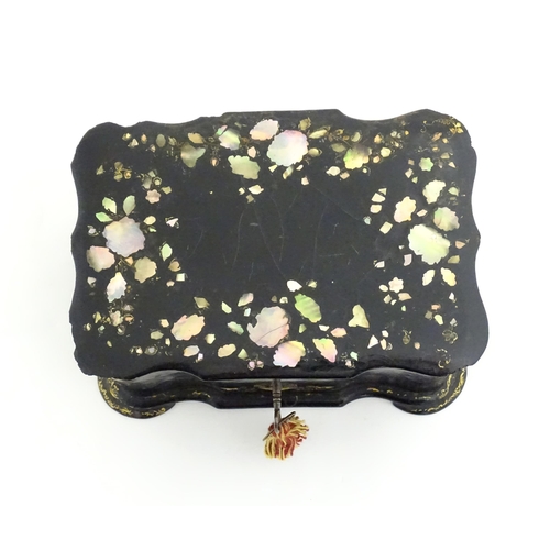 1023 - A Victorian papier mache tea caddy with inlaid abalone decoration, opening to reveal two lidded comp... 