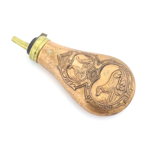 A 20thC copper and brass gun powder flask with embossed decoration