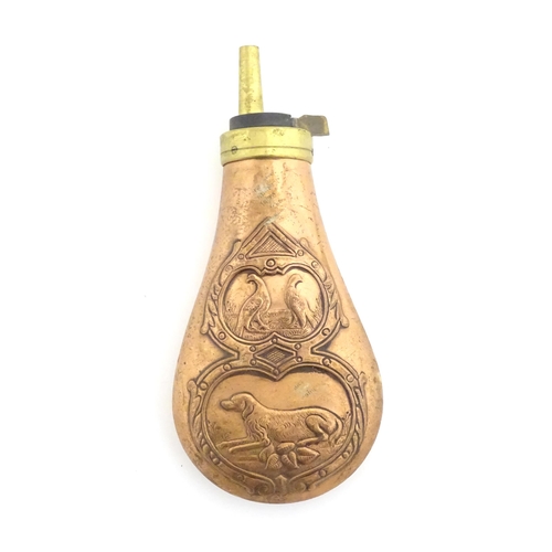 1037 - A 20thC copper and brass gun powder flask with embossed decoration depicting a gun dog and two game ... 