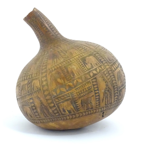 1046 - Ethnographic / Native / Tribal: An African gourd vase with incised decoration depicting elephants, z... 