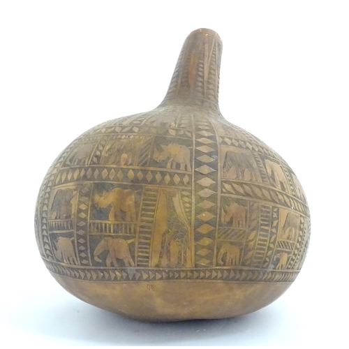 1046 - Ethnographic / Native / Tribal: An African gourd vase with incised decoration depicting elephants, z... 