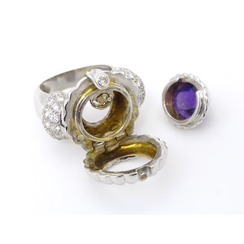 551 - An unusual 18ct white gold ring set with amethyst cabochon flanked by diamonds to shoulders. The top... 