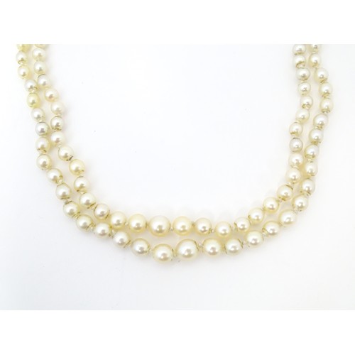 730 - A two strand graduated pearl necklace with yellow metal clasp set with agate and seed pearls. Approx... 