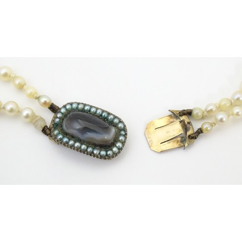 730 - A two strand graduated pearl necklace with yellow metal clasp set with agate and seed pearls. Approx... 