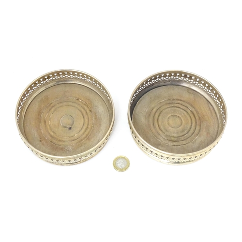 385 - A pair of silver bottle coasters with turned wooden bases, hallmarked London 1968. Approx. 5 1/4