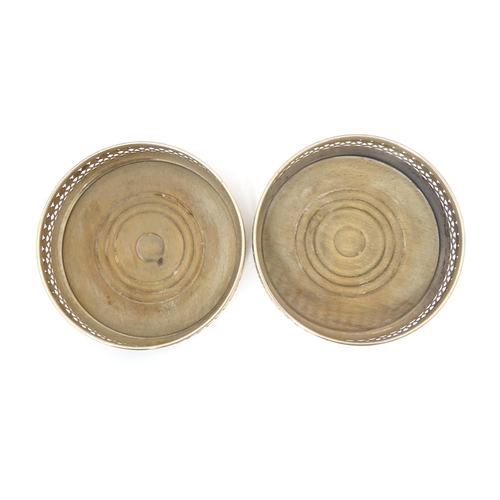 385 - A pair of silver bottle coasters with turned wooden bases, hallmarked London 1968. Approx. 5 1/4