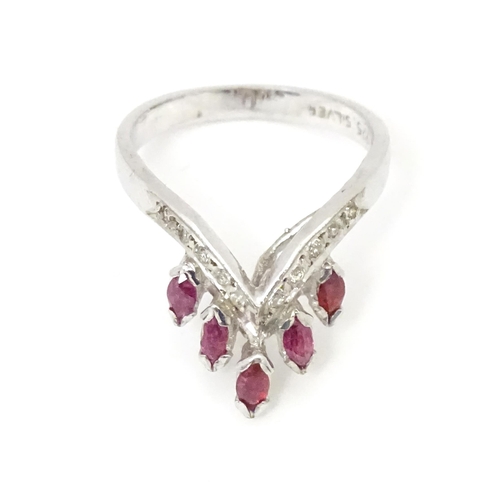 555 - A silver ring set with red and white stones. Ring size approx. M 1/2