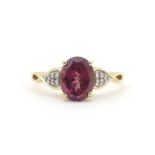 567 - A 9ct gold set with central Mahenge garnet flanked by white zircon. Ring size approx. N