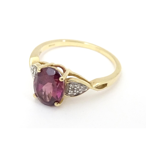 567 - A 9ct gold set with central Mahenge garnet flanked by white zircon. Ring size approx. N