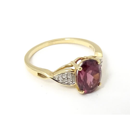 567 - A 9ct gold set with central Mahenge garnet flanked by white zircon. Ring size approx. N