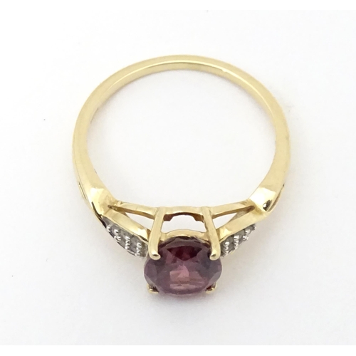 567 - A 9ct gold set with central Mahenge garnet flanked by white zircon. Ring size approx. N