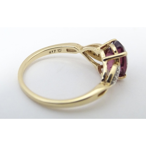 567 - A 9ct gold set with central Mahenge garnet flanked by white zircon. Ring size approx. N