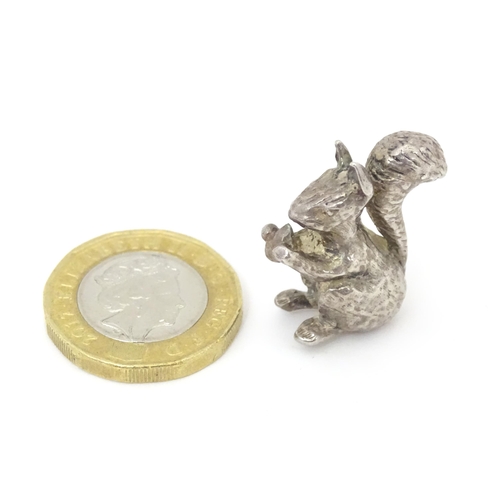 395 - A miniature silver model of a seated squirrel with a nut, hallmarked London 1976. Approx. 1