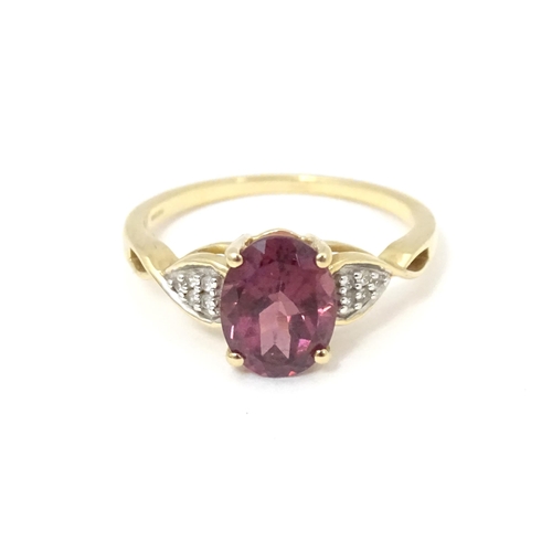 567 - A 9ct gold set with central Mahenge garnet flanked by white zircon. Ring size approx. N