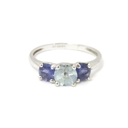 568 - A 9ct white gold ring set with central aquamarine flanked by iolite. Ring size approx. O 1/2