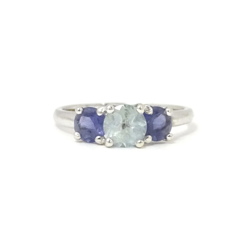 568 - A 9ct white gold ring set with central aquamarine flanked by iolite. Ring size approx. O 1/2