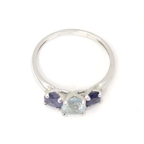 568 - A 9ct white gold ring set with central aquamarine flanked by iolite. Ring size approx. O 1/2