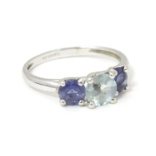 568 - A 9ct white gold ring set with central aquamarine flanked by iolite. Ring size approx. O 1/2