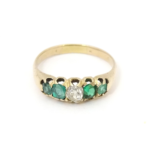 619 - An 18ct gold ring set with central diamond flanked by two emeralds. Together with insurance valuatio... 